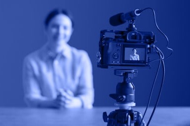 Blue Image of a Camera Pointing at a Woman