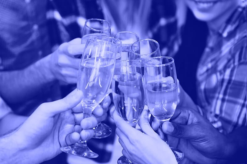 Blue Image of Seven People Tapping Prosecco Glasses