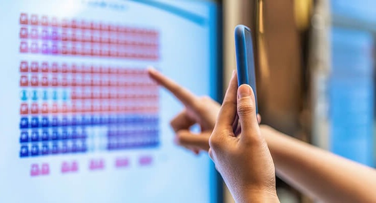 Person Holding a Phone in Front of a Screen